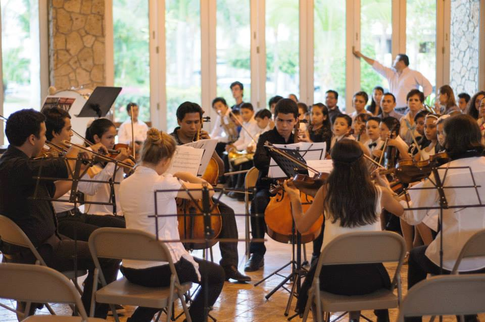 Estudiantes de la OEPV ensayando juntos en una sala